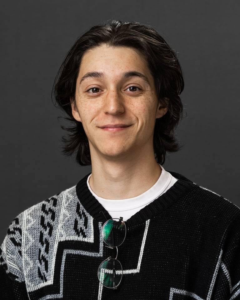 Person wearing a gray sweater smiling for a headshot